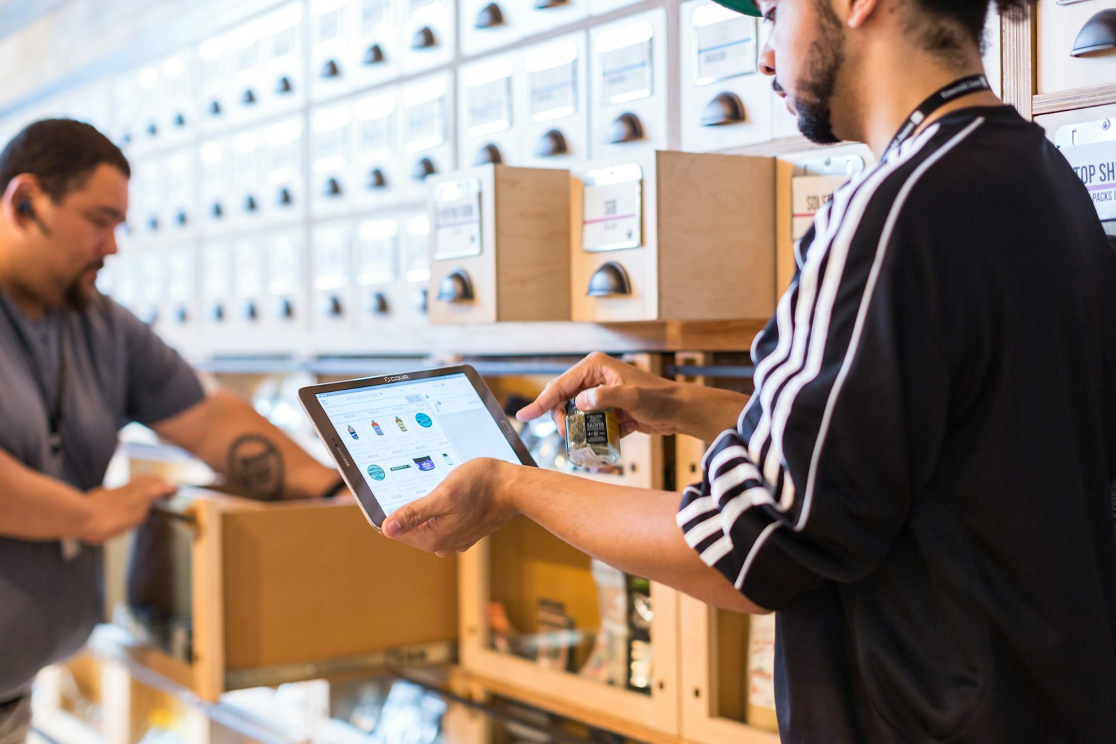 A dispensary employee using a point-of-sale tablet