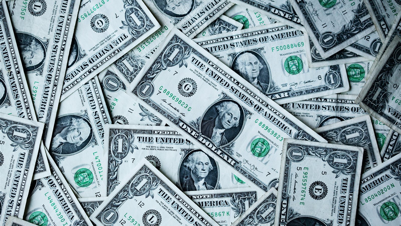 A scattered pile of U.S. dollar banknotes