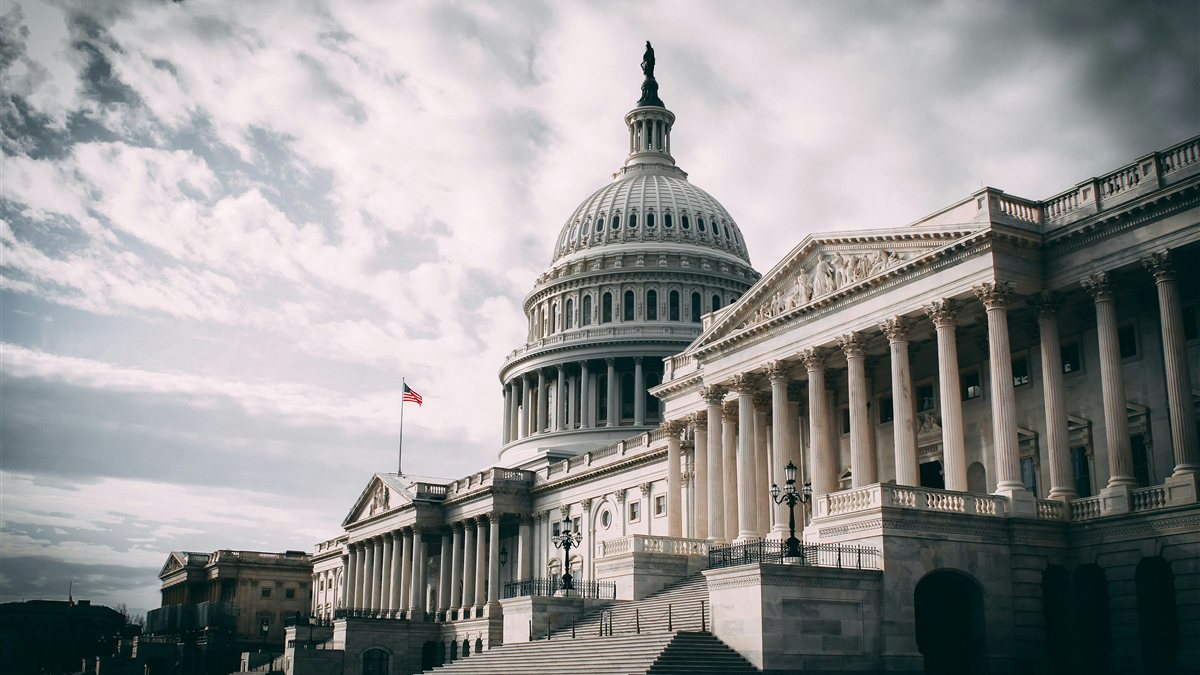 A white government building beneath a cloudy sky