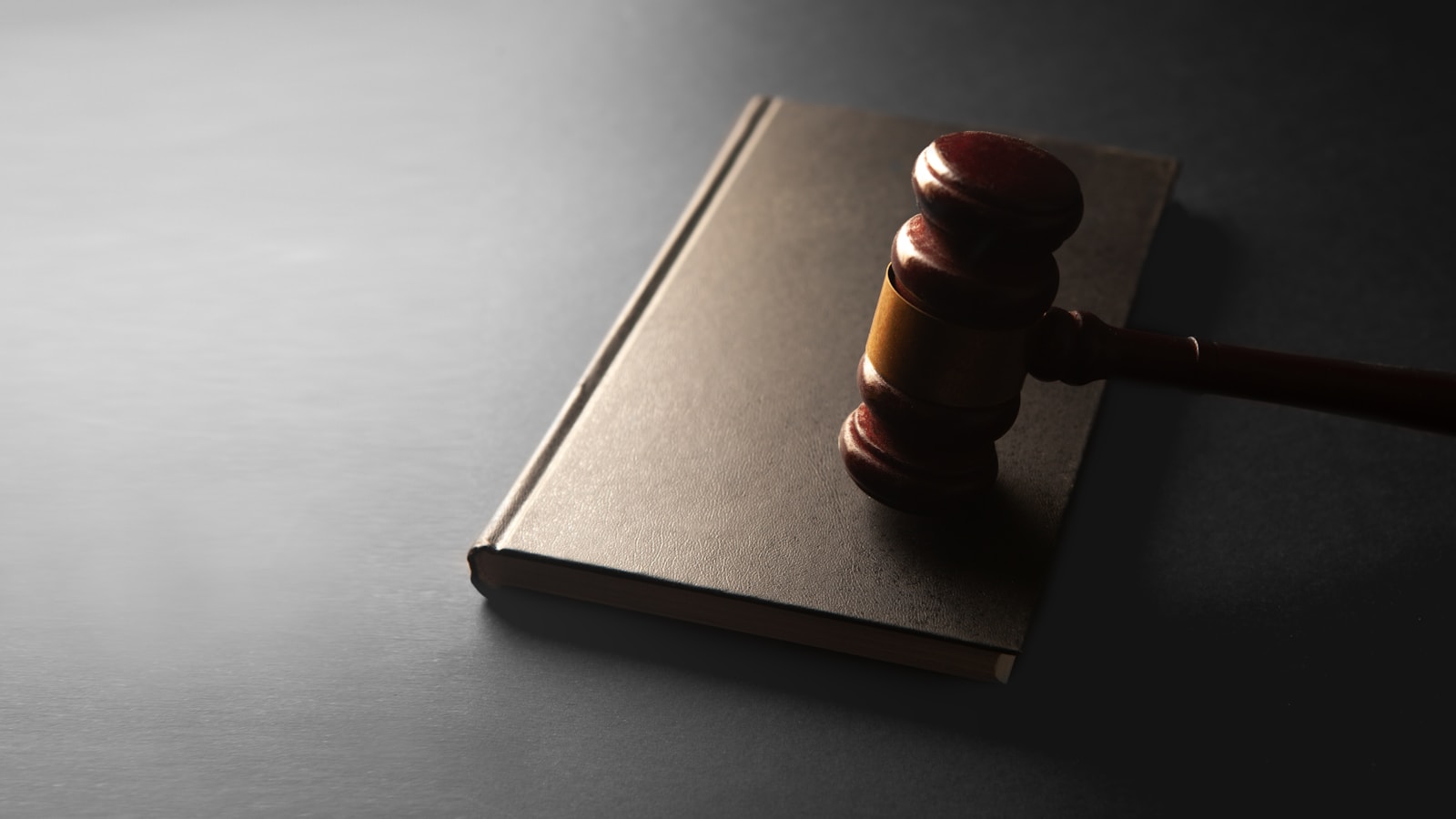 A wooden gavel resting on a closed law book
